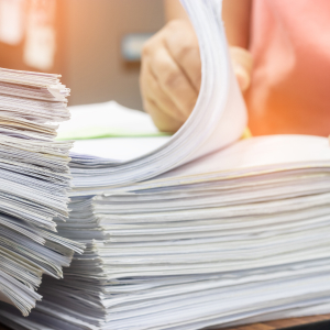 A person is holding a stack of papers